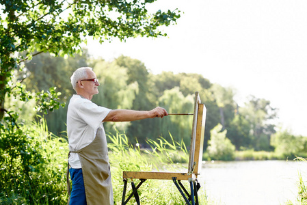 男画家画图片在白天在公园反对湖
