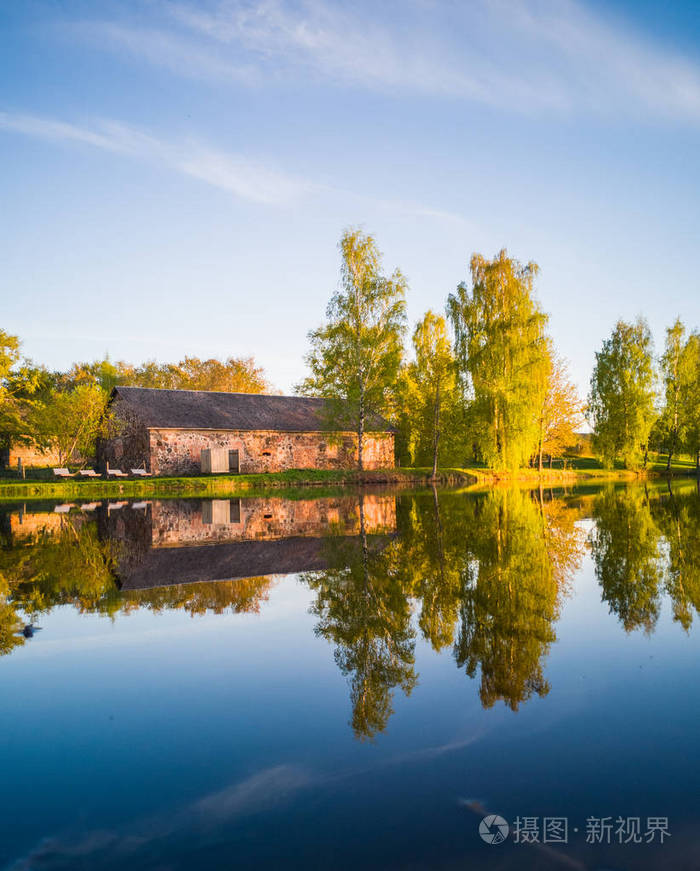 美丽的树反射在湖上的阳光明媚的春天天-秋天的颜色.
