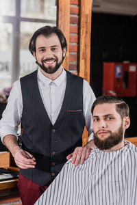 与客户在理发店微笑胡子理发师图片