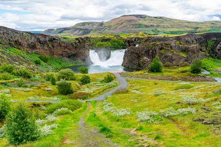 冰岛南部 Thjorsardalur 河谷的 Hjalparfoss 瀑布与花卉场观