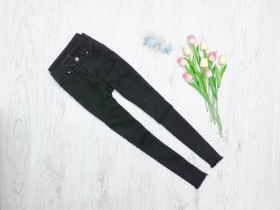 黑色牛仔裤和郁金香花束。时尚理念