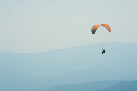 在阳光明媚的夏日, 滑翔伞飞过山谷。夏季喀尔巴阡山的滑翔伞