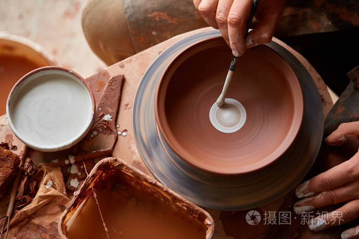 一个陶匠准备油漆在车间里用白色颜料涂上粘土板 顶部视图 特写 选择性对焦照片 正版商用图片06yq4a 摄图新视界