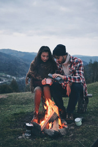 夫妇喝咖啡, 而花无忧无虑的时间在山上篝火附近