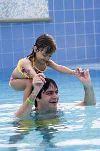 快乐的父亲在游泳大便与他的女儿玩