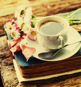 美味的咖啡和鲜花在书, 木背景