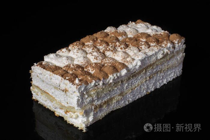 一块蛋糕特写与白色奶油洒与可可粉