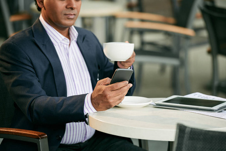 商人喝杯咖啡, 在他的智能手机阅读信息