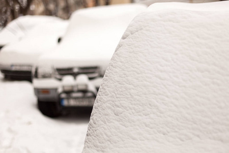 汽车覆盖着新鲜的积雪。城市中的极端降雪