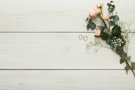 白色木材上的玫瑰和金色戒指, 婚礼背景