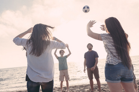 多种族集团的朋友们在海滩上打排球