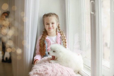 小女孩与小狗坐在窗台上