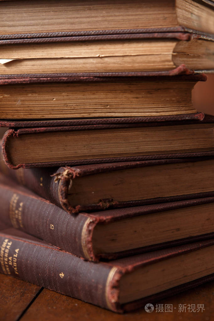 老式的木桌上的旧书.堆书.背景模糊.风光质朴,褐色,温馨照片-正版商用