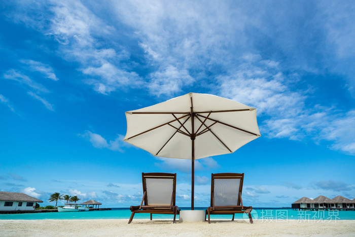 沙滩躺椅和雨伞在沙滩上休息放松假期水疗中心度假村的概念