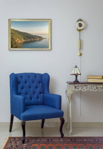 复古蓝色扶手椅的内部组成, 老式木米色表, 台灯, 书籍, 钟摆时钟在白色的墙壁, 瓷砖米色地板和橙色华丽的地毯