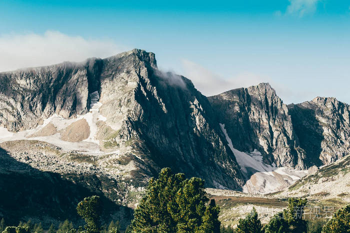 在蓝天下的岩石山脊与松树林山谷的夏日