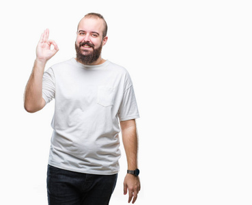 年轻的高加索嬉皮士男子穿着休闲 t恤在孤立的背景微笑积极做确定的迹象与手和手指。成功的表达