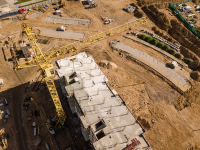 鸟瞰回黄塔建筑起重机围绕建筑工地建筑公寓楼从直升机驾驶舱视图住宅城市