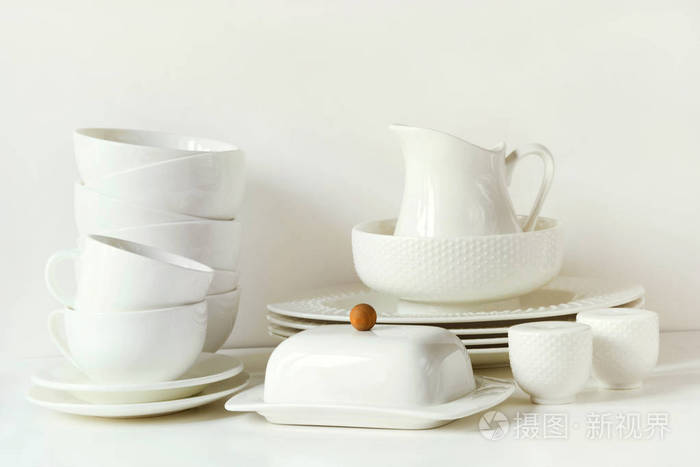 在白色桌面上的陶器, 碟子, 餐具和其他不同的白色的东西.
