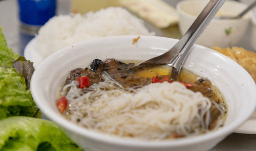 越南河内的越南菜和街头食品的烤猪肉, 米粉, 蔬菜和汤的包子茶