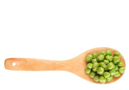在木勺在白色背景上的绿豌豆