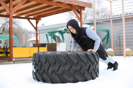 年轻肌肉人训练在重的轮胎, 室外