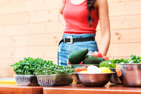 苗条的年轻妇女在厨房餐桌上的蔬菜, 健康饮食和生活方式的概念