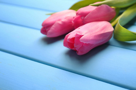 美丽的郁金香上颜色木桌前，特写