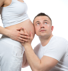 男人听婴儿婴儿在他怀孕的女人的肚子里