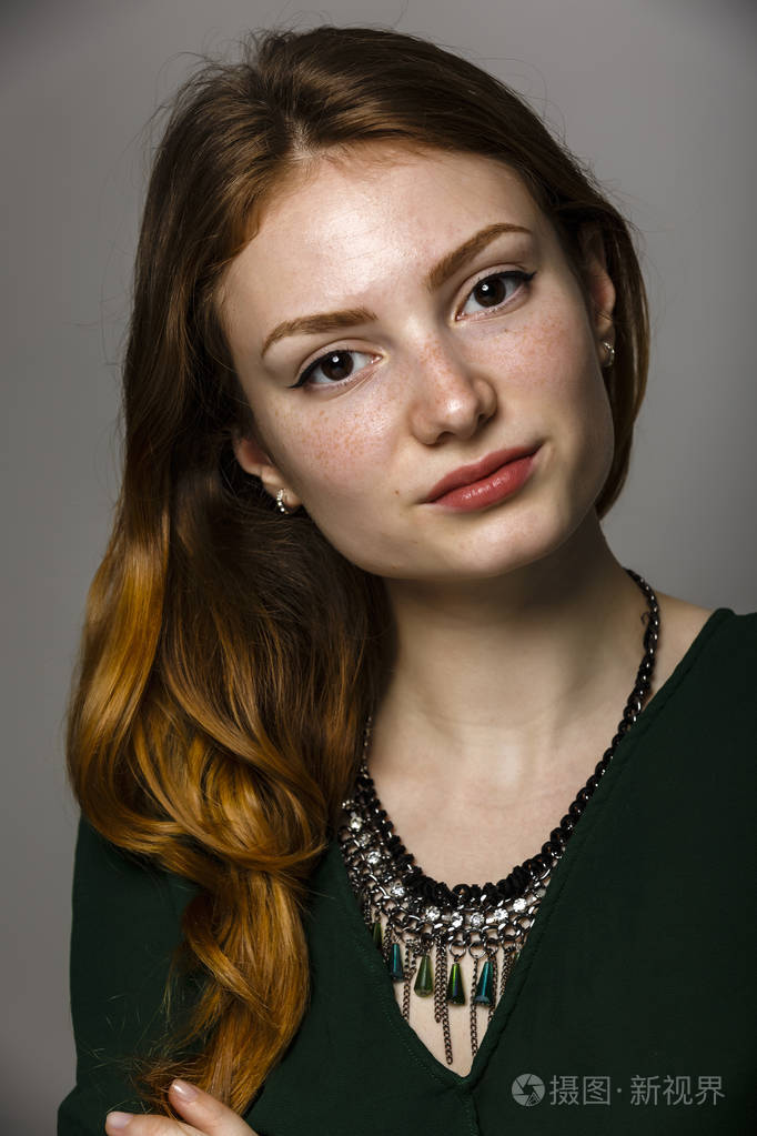 一个红色的头发和雀斑的美丽的女人的肖像