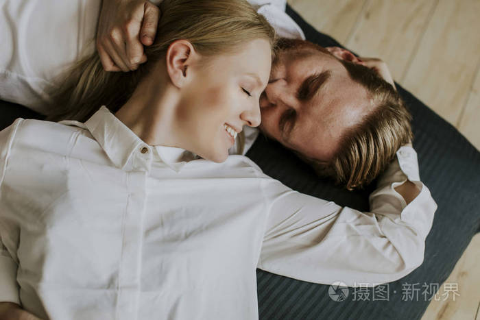 爱的情侣躺在地板上亲吻在家照片-正版商用图片071506-摄图新视界