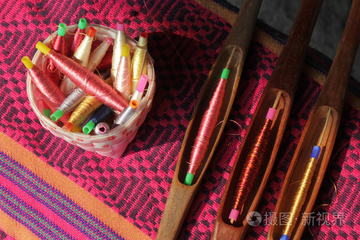 丝绸编织篮和木梭上的彩色线轴