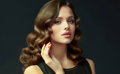 头发闪闪发亮的女孩.美丽的模特女人卷曲的发型.头发的呵护与美照片