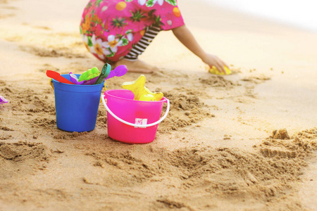 女孩的玩具在沙滩上玩耍图片