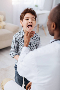 精力充沛的男孩显示舌头对医生
