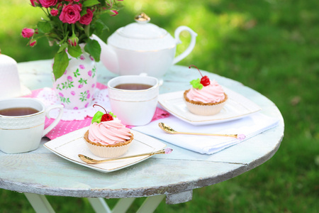 咖啡桌上的茶杯和好吃的蛋糕，在花园里