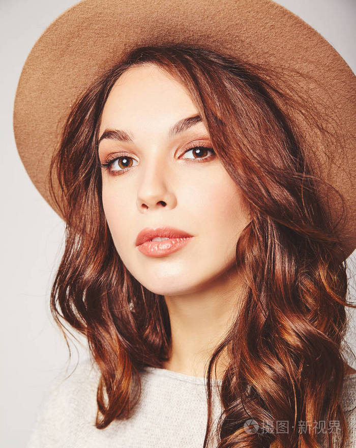 笑女孩的肖像在灰色的休闲夏天的衣服棕色帽子与自然妆隔离的灰色背景