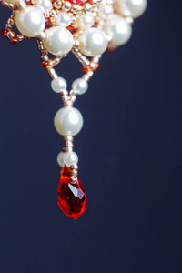 手工制作的首饰用珠在宏。白色珠子耳环。宝石耳环。漂亮的装饰品。红珠子耳环。黑色背景的装饰品