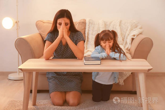 宗教基督徒女孩和她的母亲在家祈祷