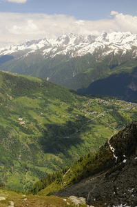 valle verdoyante avec des maisons et montagnes