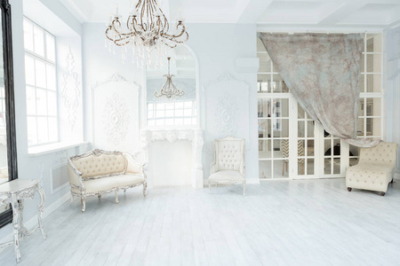 奢华丰富的起居室室内设计带有典雅的古典家具和墙壁装饰。大灯房