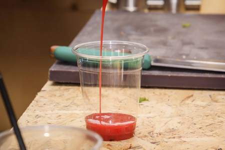 在街边咖啡厅的厨房桌子上倒入塑料玻璃杯中的西红柿汁