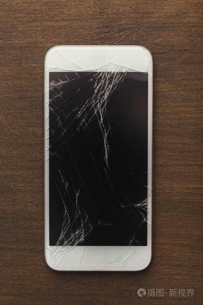 木桌上的智能手机坏了照片-正版商用图片072qns-摄图新视界