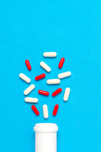 从一个蓝色的背景瓶子的药丸和胶囊。药片抗生素和药物