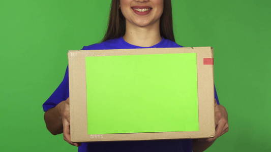 一个分娩的女人微笑着拿着 carboard 盒与 copyspace 的裁剪镜头