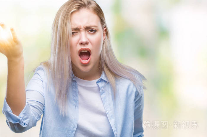 年轻的金发女人在孤立的背景愤怒和疯狂举起拳头沮丧和愤怒, 而愤怒的