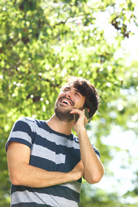 在公园里谈论手机上的快乐男人肖像