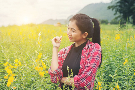 快乐的年轻美丽的女人享受夏天在黄花五