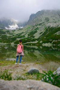 斯洛伐克旅游。少女游客看着美丽的山湖风光后景色