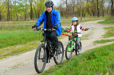 快乐的父亲和孩子骑自行车，家庭骑自行车